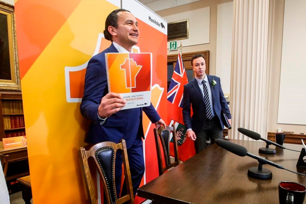 Manitoba's Opposition Progressive Conservatives are accusing the NDP government of ducking public hearings by cramming dozens of legislative measures into an omnibus budget bill. Manitoba Premier Wab Kinew, left, holds up his party’s budget as he and Finance Minister Adrien Sala speak to media before the provincial budget is read at the Manitoba legislature in Winnipeg, Tuesday, April 2, 2024. THE CANADIAN PRESS/John Woods