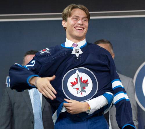 Ryan Remiorz / The Canadian Press
                                Winnipeg Jets Rutger McGroarty puts on his jersey during the first round of the 2022 NHL Draft Thursday, July 7, 2022 in Montreal. THE CANADIAN PRESS/