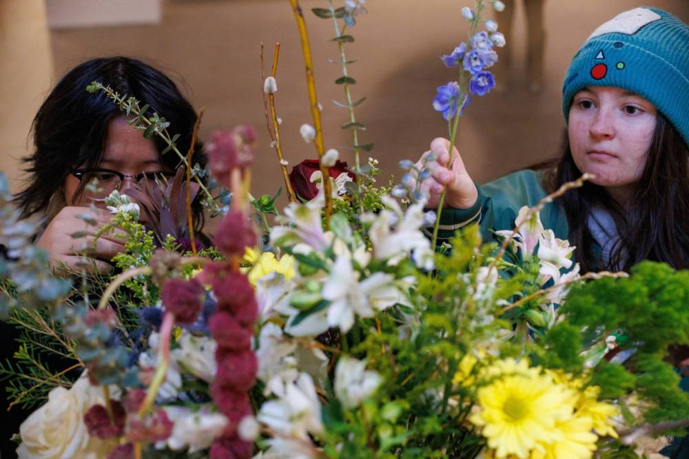Exchange Met School students Liana Montoya (left) and Kay Gillespie help arrange a display of fresh flowers.(Mike Deal / Free Press)