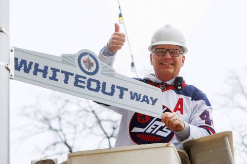 MIKE DEAL / FREE PRESS
                                Winnipeg Mayor Scott Gillingham installs a celebratory &ldquo;Whiteout Way&rdquo; street sign at Donald Street and Graham Avenue Friday.