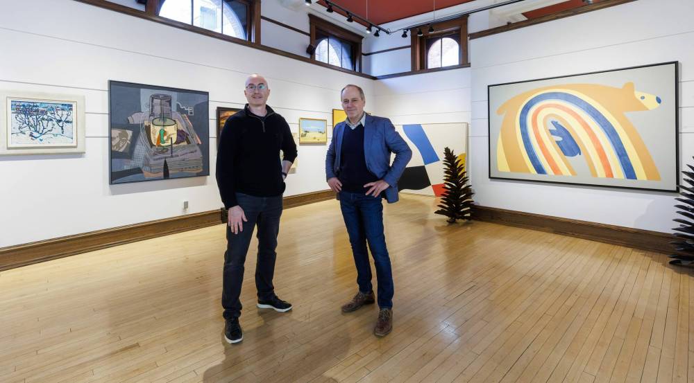 MIKE DEAL / FREE PRESS
WAG-Qaumajuq’s director and CEO Stephen Borys (right) and Shaun Mayberry with Mayberry Fine Art examine the paintings from the collection going to auction.