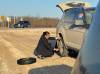 TASHA SPILLETT PHOTO 
                                Premier Wab Kinew changes a tire for Tasha Spillett after blowing a tire on her drive back to Winnipeg from a funeral April 20.