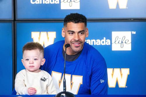 MIKAELA MACKENZIE / FREE PRESS
                                Andrew Harris, accompanied by his 18-month-old son Axton, speaks Friday at Princess Auto Stadium.