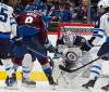 Winnipeg Jets goaltender Connor Hellebuyck, seconsd from right, stops a shot by olorado Avalanche defenseman Cale Makar (8) in the second period of Game 4 of an NHL Stanley Cup first-round playoff series Sunday, April 28, 2024, in Denver. (David Zalubowski / The Associated Press)