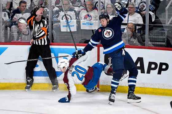 Winnipeg Jets' defenceman Logan Stanley lowers the boom on Colorado Avalanche centre Ross Colton during the first period, Sunday.  (Fred Greenslade / The Canadian Press)
