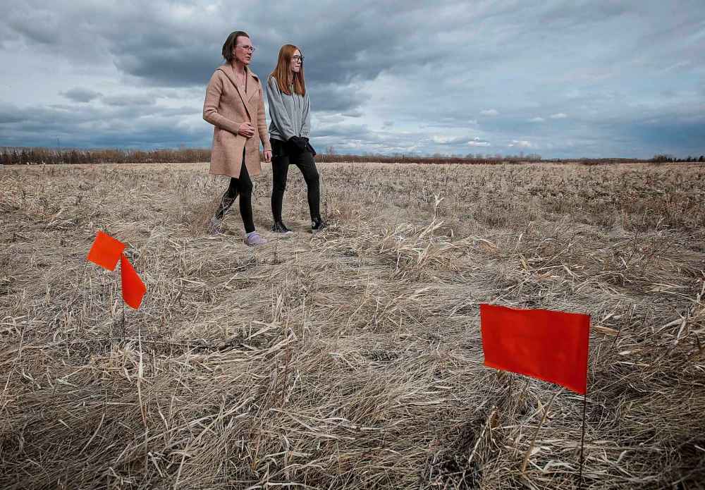 JOHN WOODS / FREE PRESS
Amber Wilson and her daughter Mia, residents of Pineridge Village in West Pine Ridge, walk near the proposed site of a pharmaceutical manufacturer Tuesday.