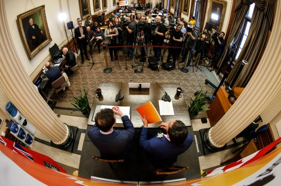 Premier Wab Kinew, right, and Finance Minister Adrien Sala speak to media before the provincial budget is read at the Manitoba legislature. (John Woods / The Canadian Press)