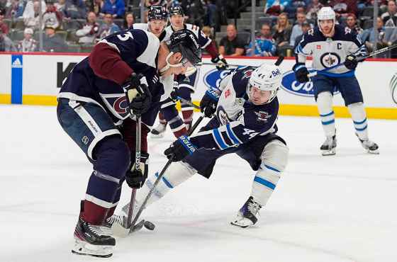 Winnipeg Jets defenseman Josh Morrissey, front right, fights for control of the puck with Colorado Avalanche defenseman Jack Johnson, left, in the game's third period April 13. (David Zalubowski / The Associated Press files)