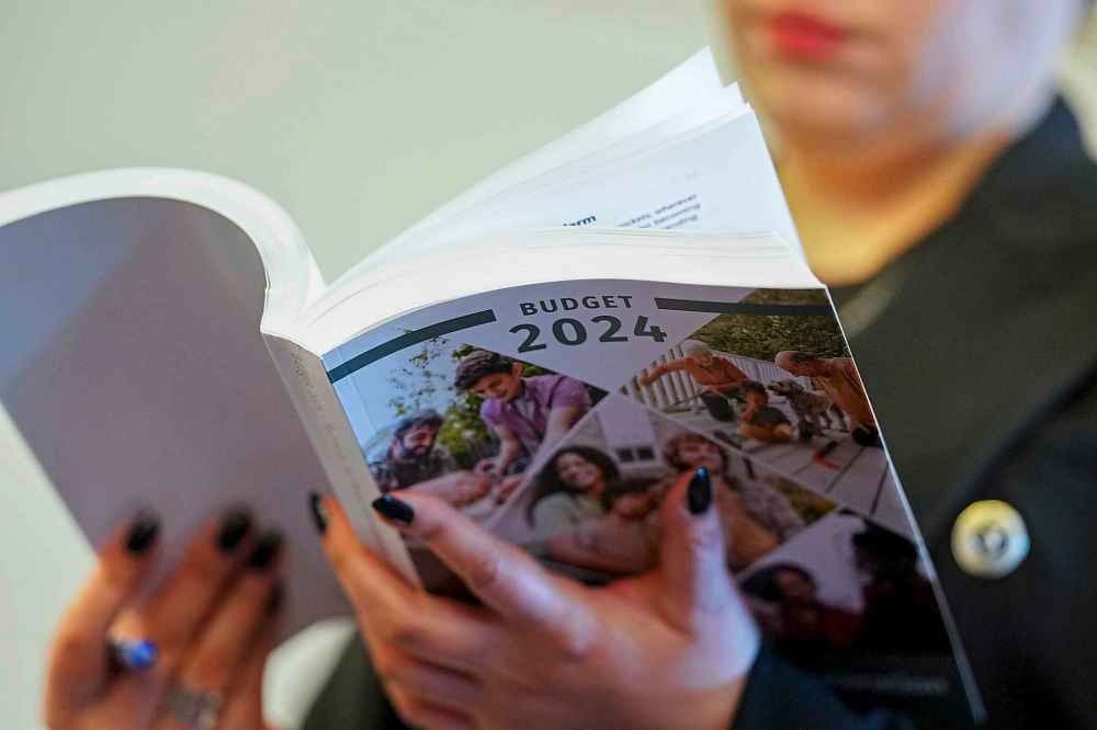 A reporter thumbs through a copy of the 2024 Budget in Ottawa on Tuesday, April 16, 2024. THE CANADIAN PRESS/Sean Kilpatrick