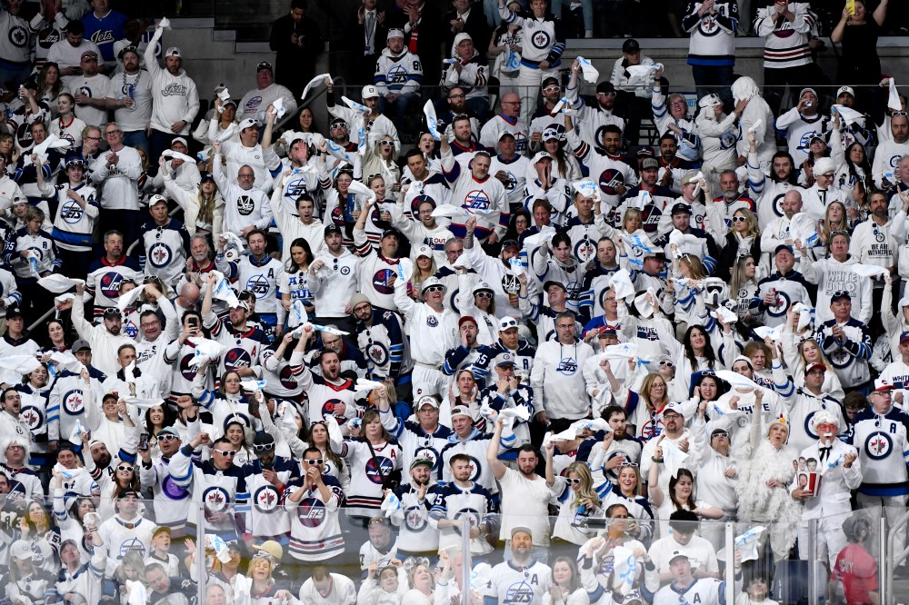Winnipeg Jets fans cheer after their team scored on the Colorado Avalanche during the second period. (Fred Greenslade / The Canadian Press)