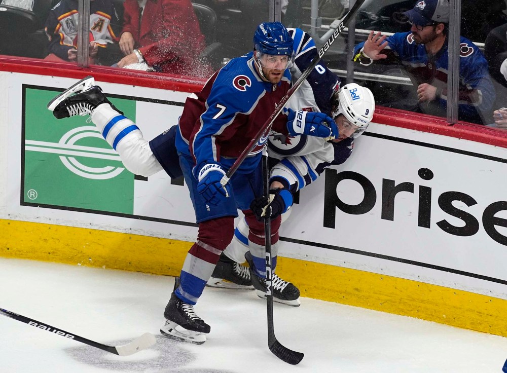 Devon Toews checks Jets winger Alex Iafallo during the first period Friday in Denver. (David Zalubowski / The Associated Press)