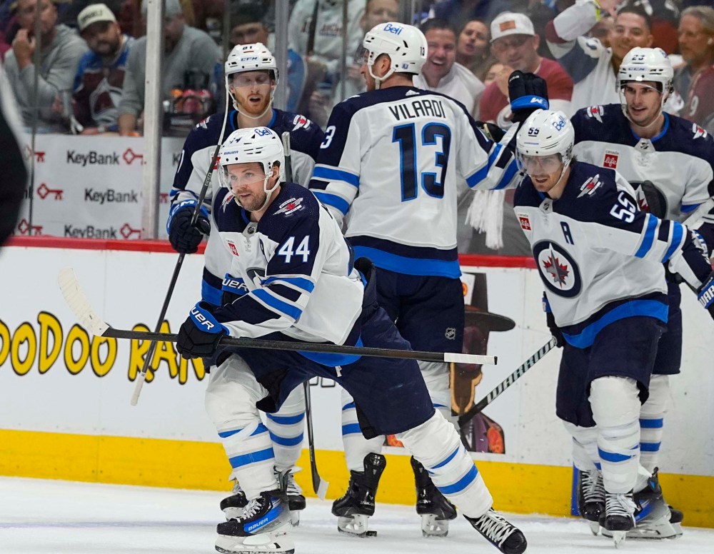 Josh Morrissey heads to the bench after celebrating his goal with his teammates during the second period Friday in Denver. (David Zalubowski / The Associated Press)