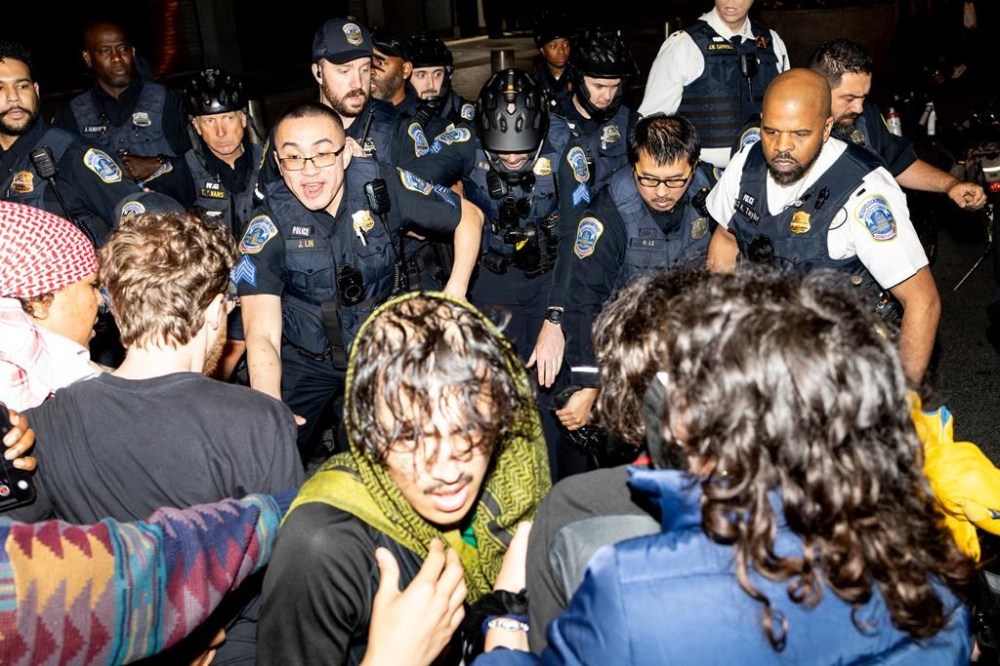 Demonstrators clash with the Metropolitan Police Department officers at George Washington University, early Wednesday, May 8, 2024, in Washington. Police cleared a pro-Palestinian tent encampment at George Washington University and arrested demonstrators early Wednesday, hours after dozens marched to the home of the school’s president. (Sage Russell, GW Hatchet via AP)