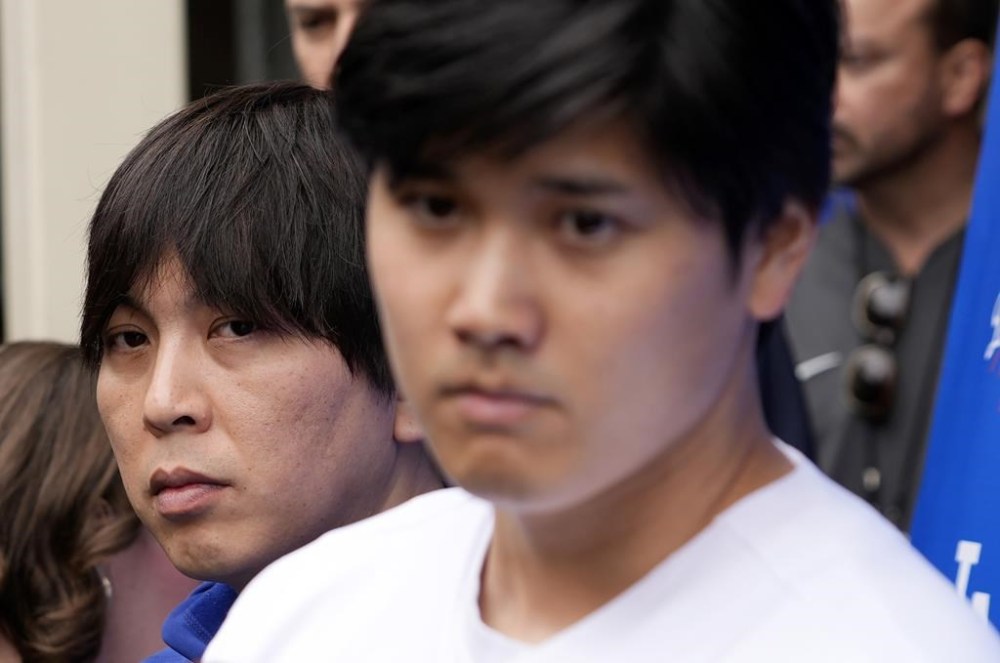 FILE - Interpreter Ippei Mizuhara stands next to Japanese baseball star Shohei Ohtani and translates during an interview at Dodger Stadium on Feb. 3, 2024, in Los Angeles. Mizuhara, the former interpreter for Ohtani pleaded guilty to bank and tax fraud Wednesday, May 8, 2024, in a sports betting case where prosecutors allege he stole $16 million from the Japanese baseball player to pay off debts. (AP Photo/Richard Vogel, File)