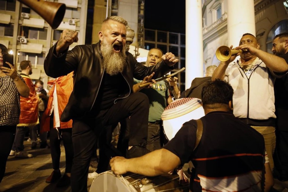 Supporters of the opposition center-right VMRO-DPMNE party celebrate in front of the party headquarters after their party announced victory in the parliamentary elections, in Skopje, North Macedonia, Wednesday, May 8, 2024. Citizens voted in North Macedonia on Wednesday in a parliamentary election and presidential runoff dominated by the country's slow path toward European Union membership and its sluggish economy. (AP Photo/Boris Grdanoski)