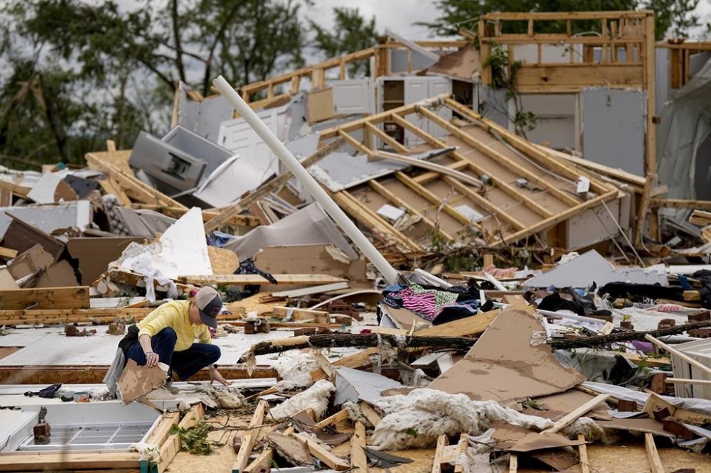 Valerie Bernhardt looks through debris at her stormed damaged home Thursday, May 9, 2024, in Columbia, Tenn. A wave of dangerous storms began crashing over parts of the South on Thursday, a day after severe weather with damaging tornadoes killed at least three people in the region. (AP Photo/George Walker IV)