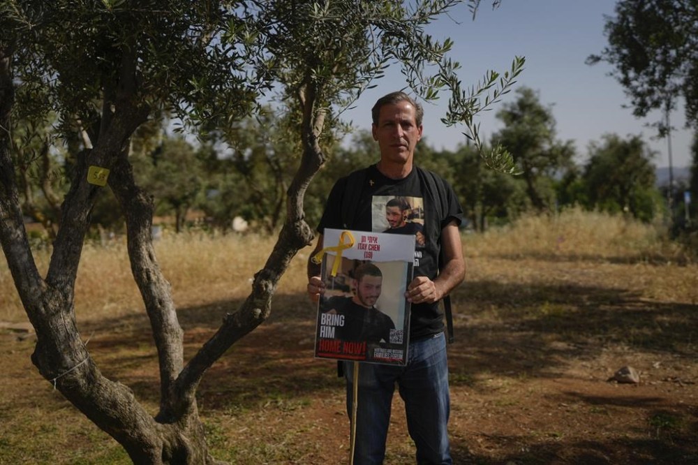Ruby Chen holds a poster of his son, Itay Chen, during a protest near Israel's parliament in Jerusalem, on Thursday, March 9, 2024. Itay Chen was killed in Hamas' attack on Oct. 7. But unlike scores of other families of soldiers killed that day, the Chens don't have a grave to visit because their son's remains are being held by Hamas in Gaza. The absence of a final resting place is being felt by several dozen families as Israel marks its memorial day for fallen soldiers, when cemeteries are brimming with relatives mourning over the graves of their loved ones. (AP Photo/Ohad Zwigenberg)
