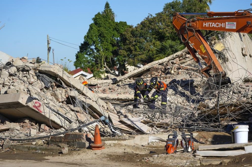 Rescue personnel search the site of a building collapse in George, South Africa, Thursday, May 9, 2024. Rescue teams, searching for dozens of construction workers missing after a multi-story apartment complex collapsed in the coastal city, have not brought out more survivors in the past 24 hours. (AP Photo/Jerome Delay)
