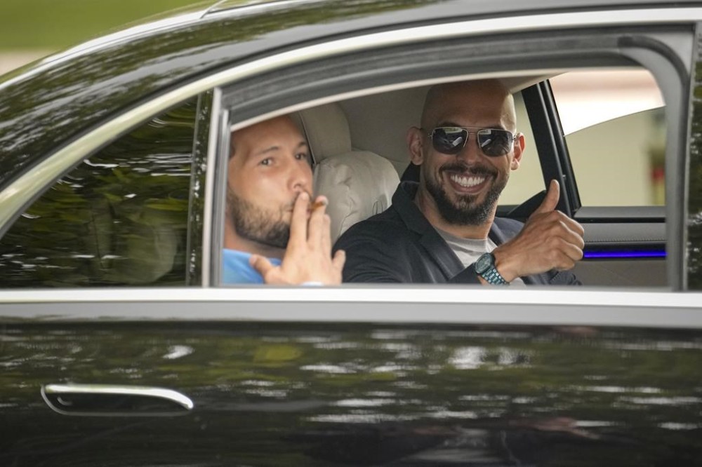 Andrew Tate, right, and his brother Tristan gesture as they leave the Bucharest Tribunal in Bucharest, Romania, Wednesday, May 8, 2024. A court in Romania's capital ruled on April 26, that a trial could start but did not set a date for the trial to begin in the case of influencer Andrew Tate, who is charged with human trafficking, rape and forming a criminal gang to sexually exploit women. (AP Photo/Vadim Ghirda)