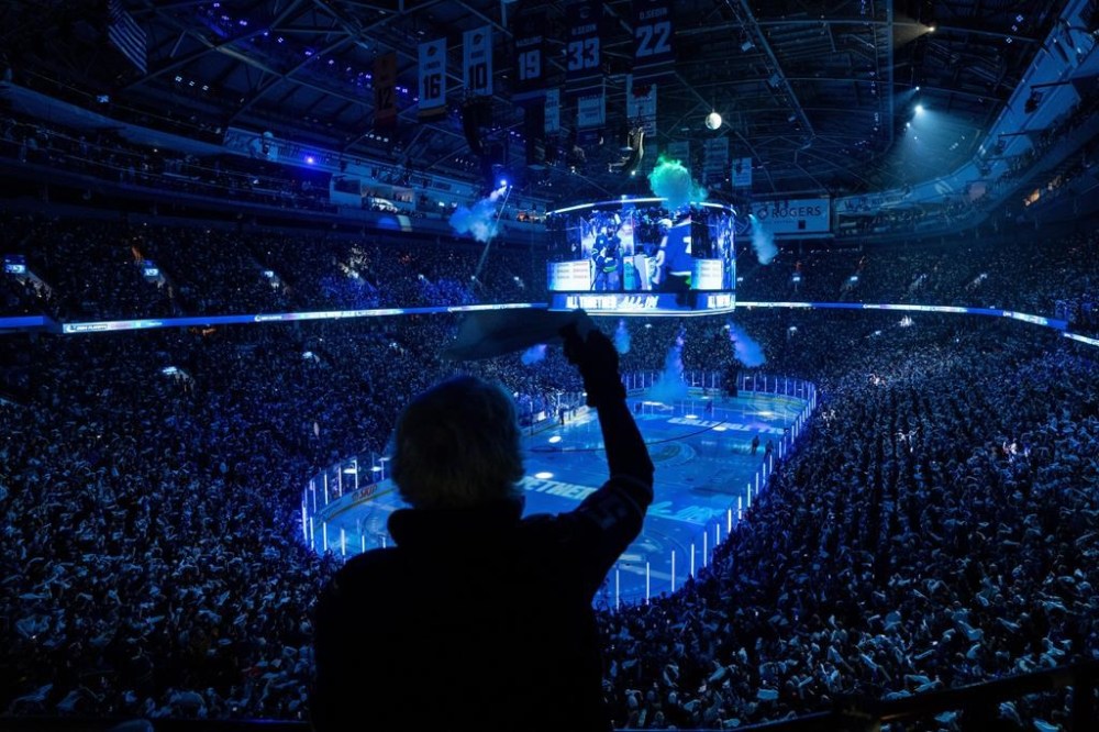 A fan waves a towel as players enter the ice before the Edmonton Oilers and the Vancouver Canucks play Game 1 of an NHL hockey Stanley Cup second-round playoff series, in Vancouver, on Wednesday, May 8, 2024. THE CANADIAN PRESS/Ethan Cairns