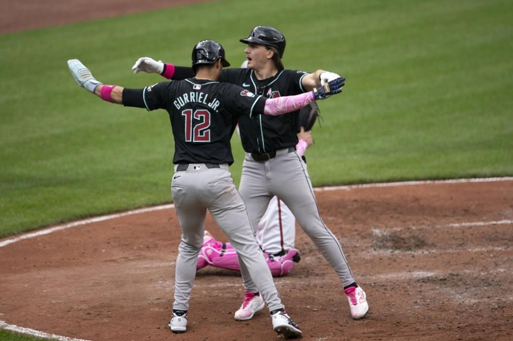 Arizona Diamondbacks' Lourdes Gurriel Jr. (12) celebrates with teammate Jake McCarthy, right, after scoring a run during a baseball game against the Baltimore Orioles, Sunday, May 12, 2024, in Baltimore. (AP Photo/Jose Luis Magana)
