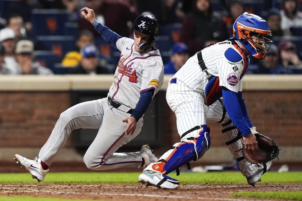 Atlanta Braves' Zack Short, left, scores after Marcell Ozuna (not shown) singled on a ground ball during the eighth inning of a baseball game against the New York Mets, Sunday, May 12, 2024, in New York. (AP Photo/Julia Nikhinson)