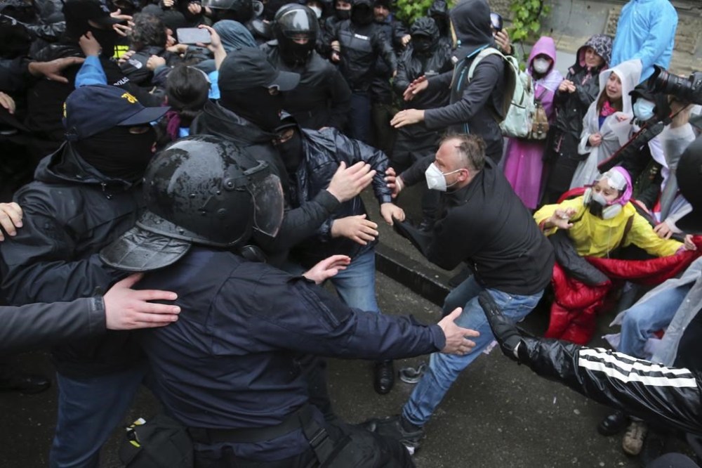 Police try to detain a demonstrator near the Parliament building during an opposition protest against