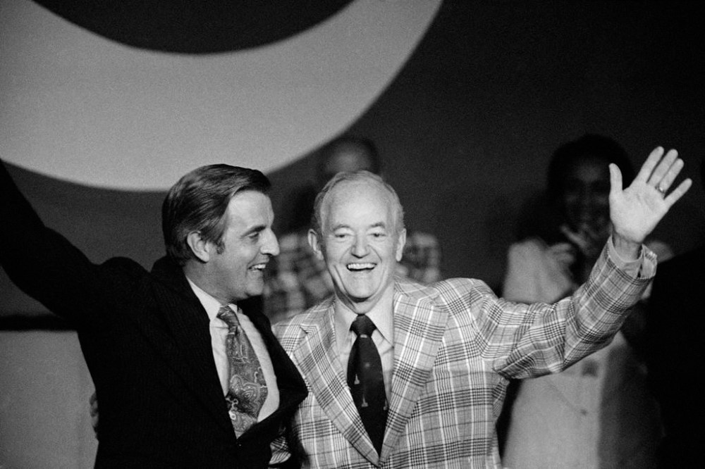 FILE - U.S. Vice President Walter Mondale, left and Sen. Hubert Humphrey share a laugh after they embraced upon greeting each other on the podium of the National Education Assn. meeting, July 5, 1977 in Minneapolis, Minn, where Mondale was guest speaker and Humphrey was presented the