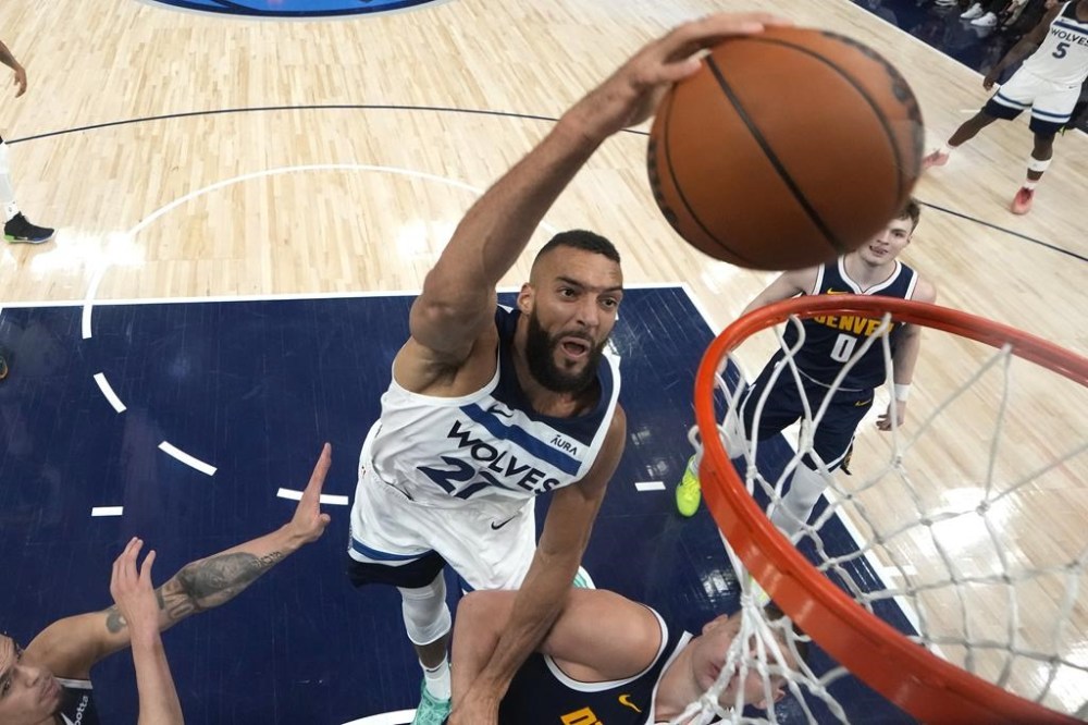 Minnesota Timberwolves center Rudy Gobert (27) dunks against Denver Nuggets center Nikola Jokic, bottom, during the second half of Game 4 of an NBA basketball second-round playoff series, Sunday, May 12, 2024, in Minneapolis. (AP Photo/Abbie Parr)