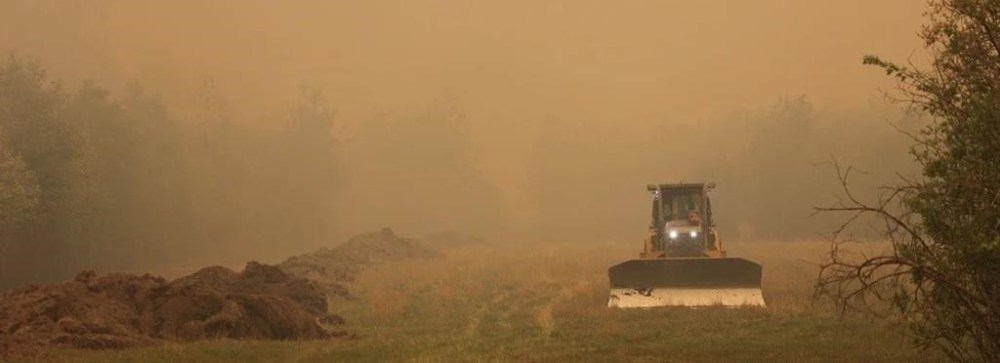 Fire crews battling a blaze outside Fort McMurray are expecting a little help from the weather today while crews working a wildfire, designated GCU007 by the Alberta Wildfire Service, near Grande Prairie say they expect unfavourable winds and no rain. An operator drives a bulldozer beside ditches dug to create a perimeter for a forest fire in an undated handout photo. THE CANADIAN PRESS/HO-Alberta Wildfire Service, *MANDATORY CREDIT*