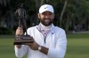 Scottie Scheffler holds the trophy after winning the weather delayed RBC Heritage golf tournament, Monday, April 22, 2024, in Hilton Head Island, S.C. (AP Photo/Chris Carlson)