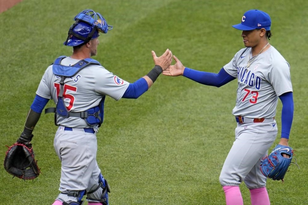 Chicago Cubs relief pitcher Adbert Alzolay (73) celebrates with catcher Yan Gomes, left, after getting the final out in the 10th inning to preserve a win over the Pittsburgh Pirates in a baseball game in Pittsburgh, Sunday, May 12, 2024. (AP Photo/Gene J. Puskar)