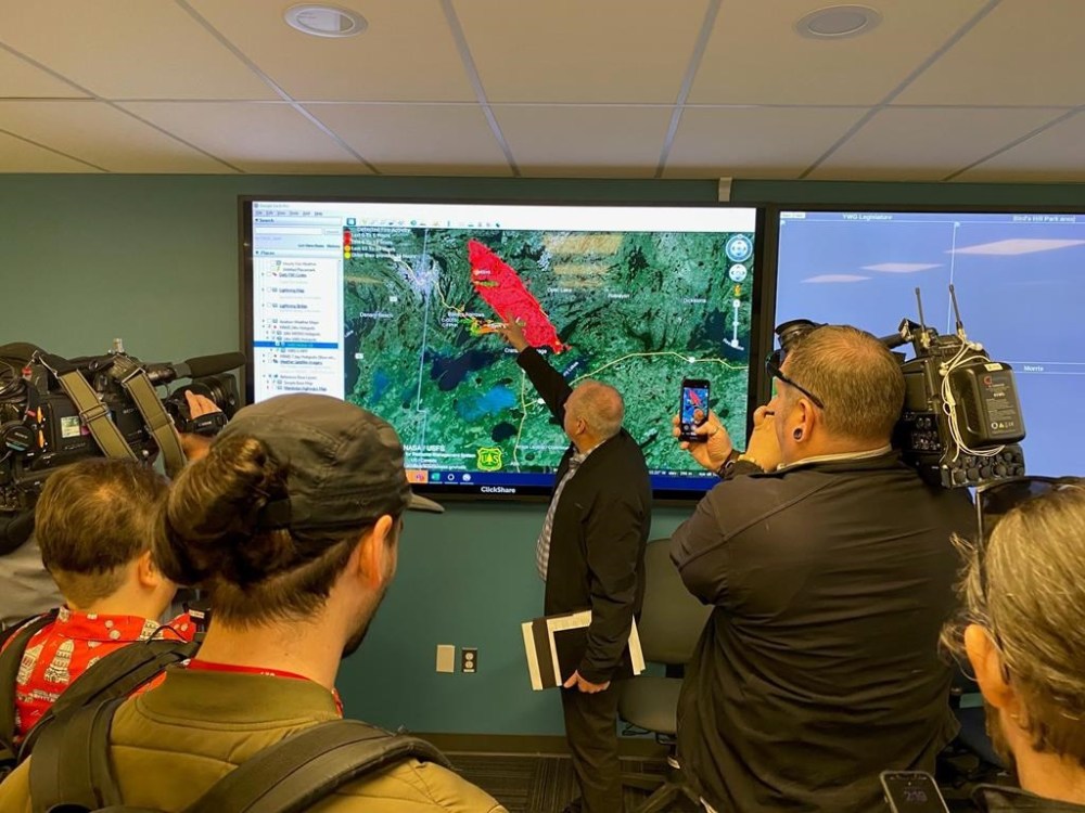 Director of the Manitoba Wildfire Service, Earl Simmons, centre, shows the location of an out-of-control wildfire the province is currently fighting near Flin Flon, Man., in a Monday, May 13, 2024, handout photo. THE CANADIAN PRESS/HO-Government of Manitoba, *MANDATORY CREDIT*