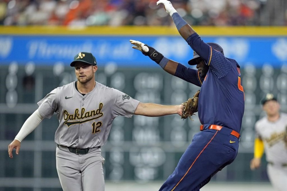 Houston Astros' Yordan Alvarez, right, is tagged out by Oakland Athletics shortstop Max Schuemann (12) during the sixth inning of a baseball game Monday, May 13, 2024, in Houston. (AP Photo/David J. Phillip)