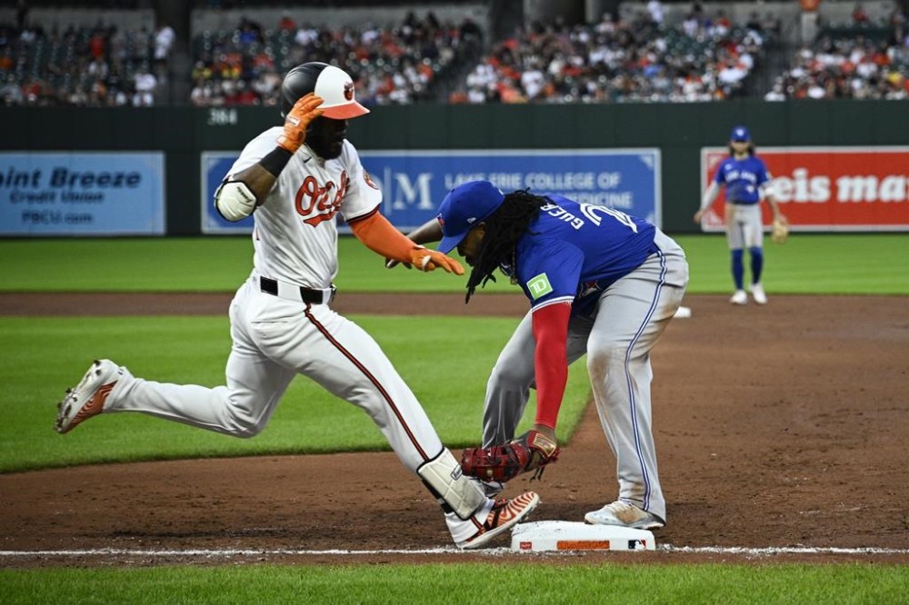 Baltimore Orioles' Cedric Mullins, left, is out at first against Toronto Blue Jays first baseman Vladimir Guerrero Jr., right, during the fifth inning of a baseball game, Monday, May 13, 2024, in Baltimore. (AP Photo/Nick Wass)