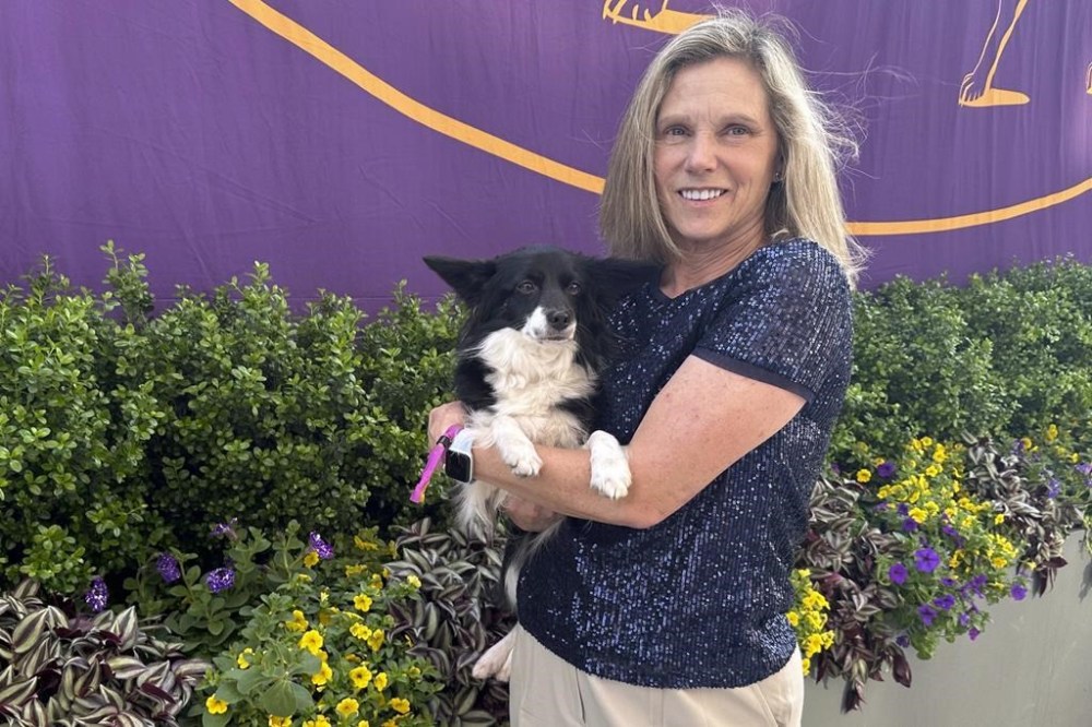 Cynthia Hornor poses with Nimble, the first mixed-breed dog ever to win the Westminster Kennel Club dog show's agility competition, on the show grounds at the USTA Billie Jean King National Tennis Center in New York, Monday, May 13, 2024. (AP Photo/Jennifer Peltz)