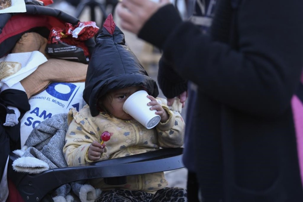 A child eats a free breakfast served by a soup kitchen that was set up at the Obelisk as a protest against the city government's