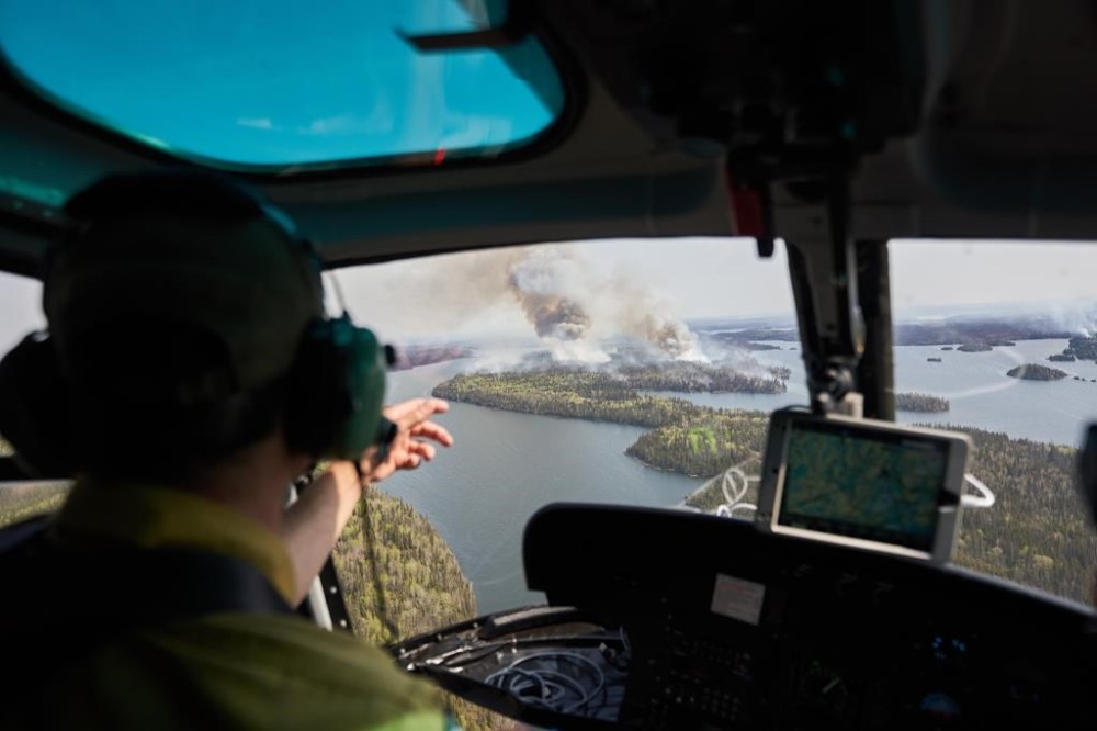 Manitoba Wildfire Service Area Fire Manager Sam Done surveys wildfires burning in northern Manitoba from a helicopter on Tuesday, May 14, 2024. THE CANADIAN PRESS/David Lipnowski