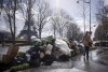 FILE - A woman walks past a pile of uncollected garbage near Eiffel Tower in Paris, Friday, March 24, 2023. Paris garbage collectors have lifted the strike notice that threatened to leave the French capital city under piles of junk during the Olympic Games after striking a deal that will improve their pay. Paris City Hall said in a statement on Wednesday, May 15, 2024 it sealed a deal with the workers and that the strike notice covering several days in May and a period from July to Sept. 8 had been lifted (AP Photo/Thomas Padilla, File)