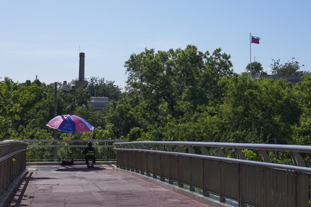 A security guard keeps watch on a pedestrian bridge near the Russian Embassy in Beijing, Wednesday, May 15, 2024. Russian President Vladimir Putin will make a two-day state visit to China this week, the Chinese Foreign Ministry said Tuesday, in the latest show of unity between the two authoritarian allies against the U.S.-led Western liberal global order. (AP Photo/Andy Wong)