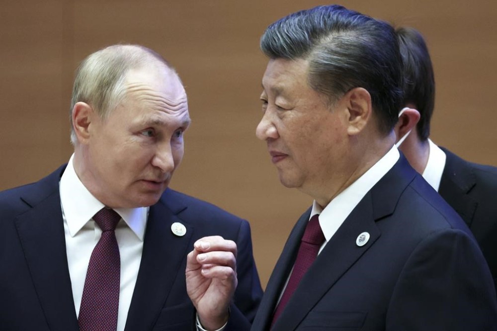 FILE- Russian President Vladimir Putin, left, gestures while speaking to Chinese President Xi Jinping during the Shanghai Cooperation Organization (SCO) summit in Samarkand, Uzbekistan, Friday, Sept. 16, 2022. Putin says his regime is prepared to negotiate over the conflict in Ukraine in an interview with Chinese media on the eve of visit to partner Beijing that has backed Moscow in its full-scale invasion of its neighbor. (Sergei Bobylev, Sputnik, Kremlin Pool Photo via AP, File)
