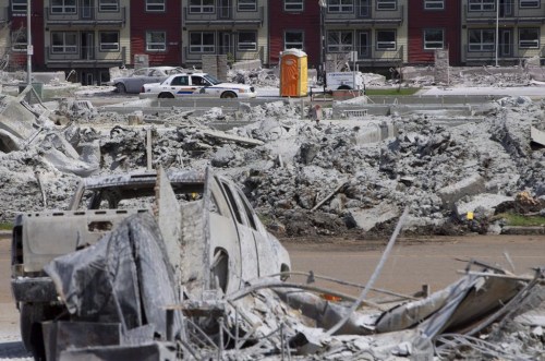 A police car drives through a burnt out Timberlea neighbourhood in Fort McMurray, Alta., on Thursday, June 2, 2016. A fierce wildfire burning outside of Fort McMurray has brought back memories of the vicious blaze, nicknamed The Beast, that tore through the Alberta oilsands hub in 2016. THE CANADIAN PRESS/Jason Franson