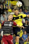 Nashville SC defender Walker Zimmerman (25) heads the ball over Toronto FC defender Sigurd Rosted (17) during the second half of an MLS soccer match Wednesday, May 15, 2024, in Nashville, Tenn. (AP Photo/George Walker IV)