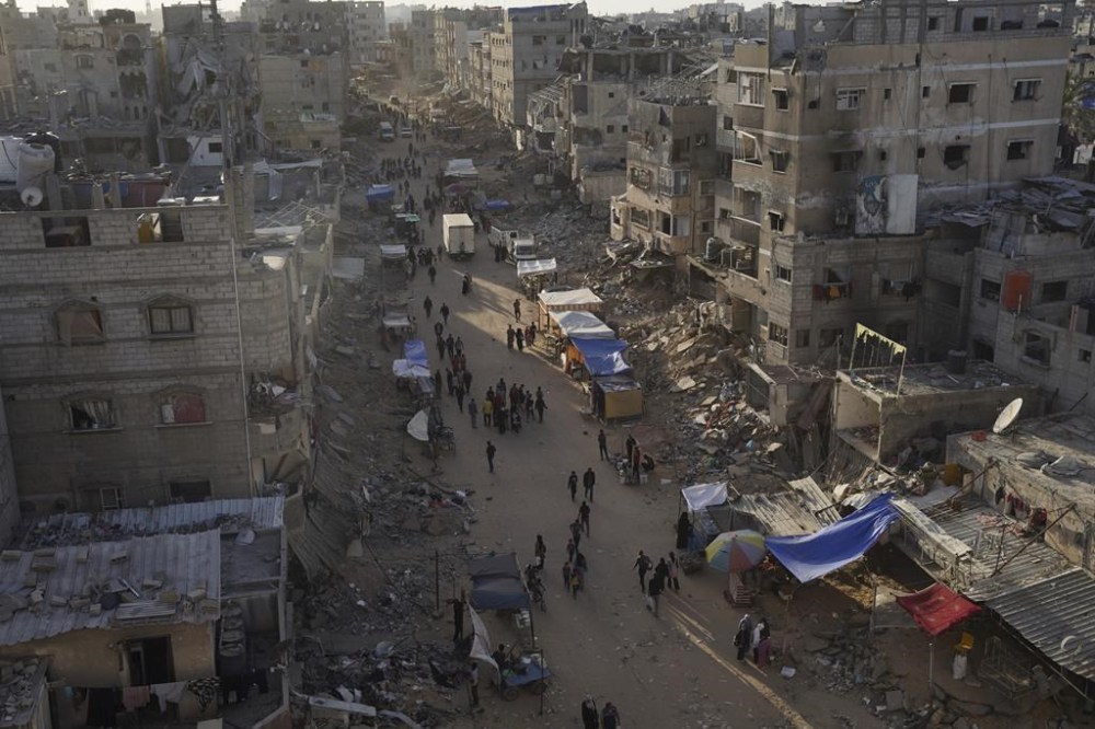 Palestinians walk through the debris after an Israeli air and ground offensive in Khan Younis, southern Gaza Strip, Wednesday, May 15, 2024. (AP Photo/Saher Alghorra)