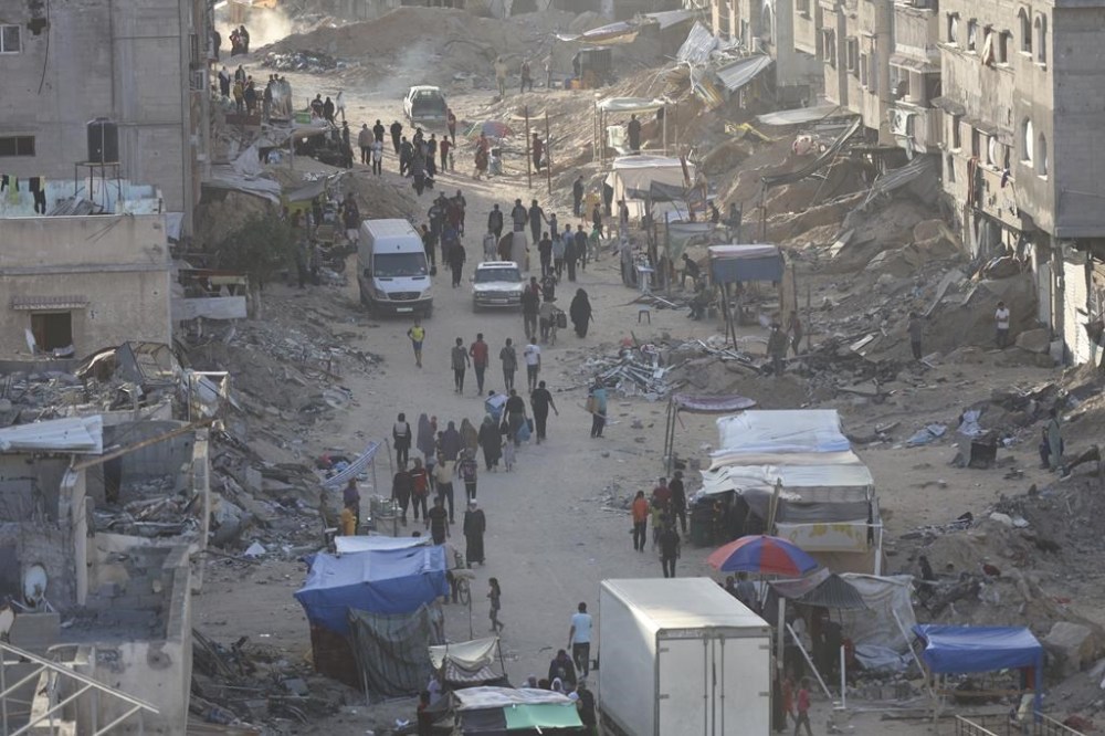 Palestinians walk through the debris after an Israeli air and ground offensive in Khan Younis, southern Gaza Strip, Wednesday, May 15, 2024. (AP Photo/Saher Alghorra)