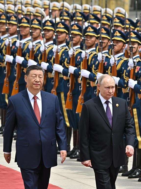 Chinese President Xi Jinping, left, and Russian President Vladimir Putin review the honor guard during an official welcome ceremony in Beijing, China, Thursday, May 16, 2024. (Sergei Bobylev, Sputnik, Kremlin Pool Photo via AP)