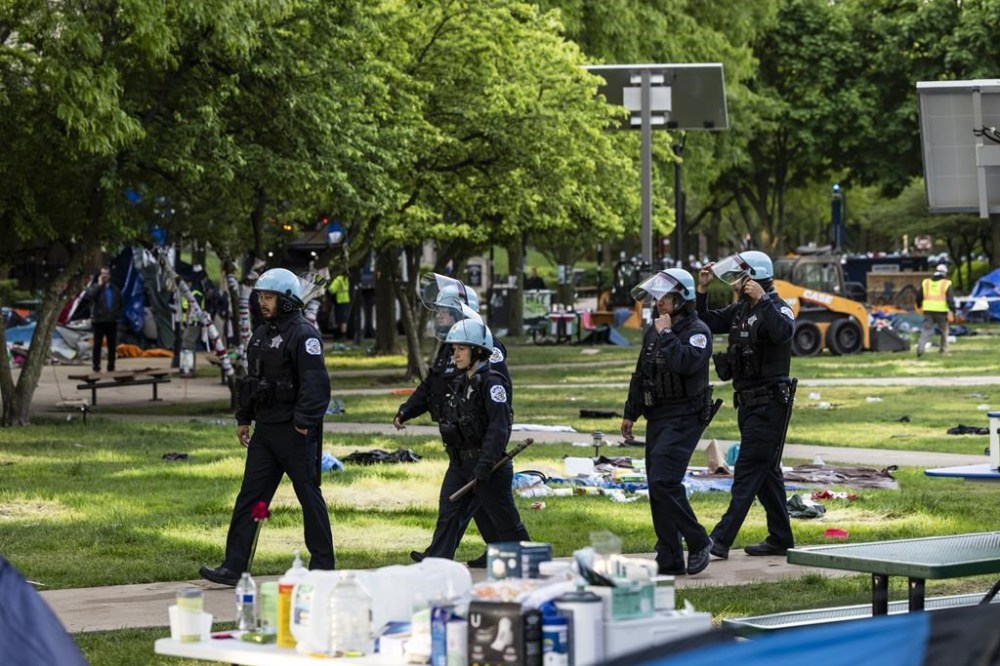 Chicago police officers walk through the quad as crews disassemble the pro-Palestinian protest encampment at DePaul University's Lincoln Park campus in Chicago, Thursday, May 16, 2024. (Ashlee Rezin/Chicago Sun-Times via AP)