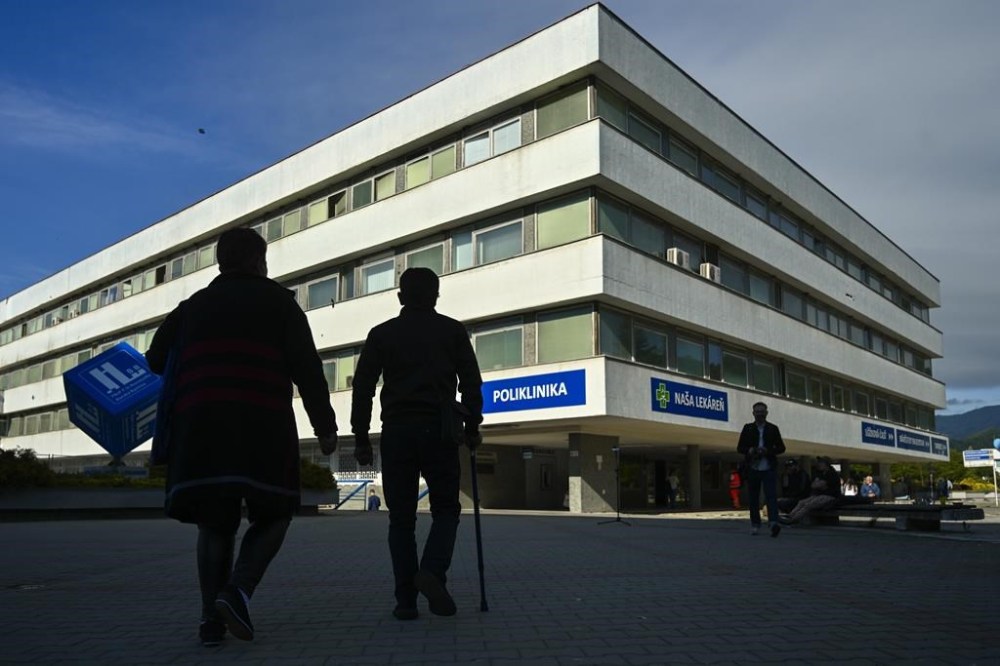 People walk outside the F. D. Roosevelt University Hospital, where Slovak Prime Minister Robert Fico, who was shot and injured, is treated in Banska Bystrica, central Slovakia, Thursday, May 16, 2024. Slovakia's populist Prime Minister Robert Fico was shot multiple times and gravely wounded Wednesday, but his deputy prime minister said he believed Fico would survive. (AP Photo/Denes Erdos)