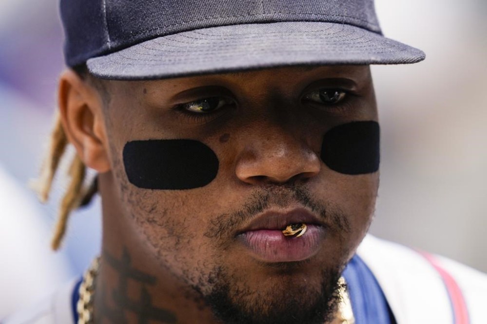 Atlanta Braves' Ronald Acuña Jr. stands in the dugout before a baseball game against the Los Angeles Dodgers in Los Angeles, Sunday, May 5, 2024. (AP Photo/Ashley Landis)