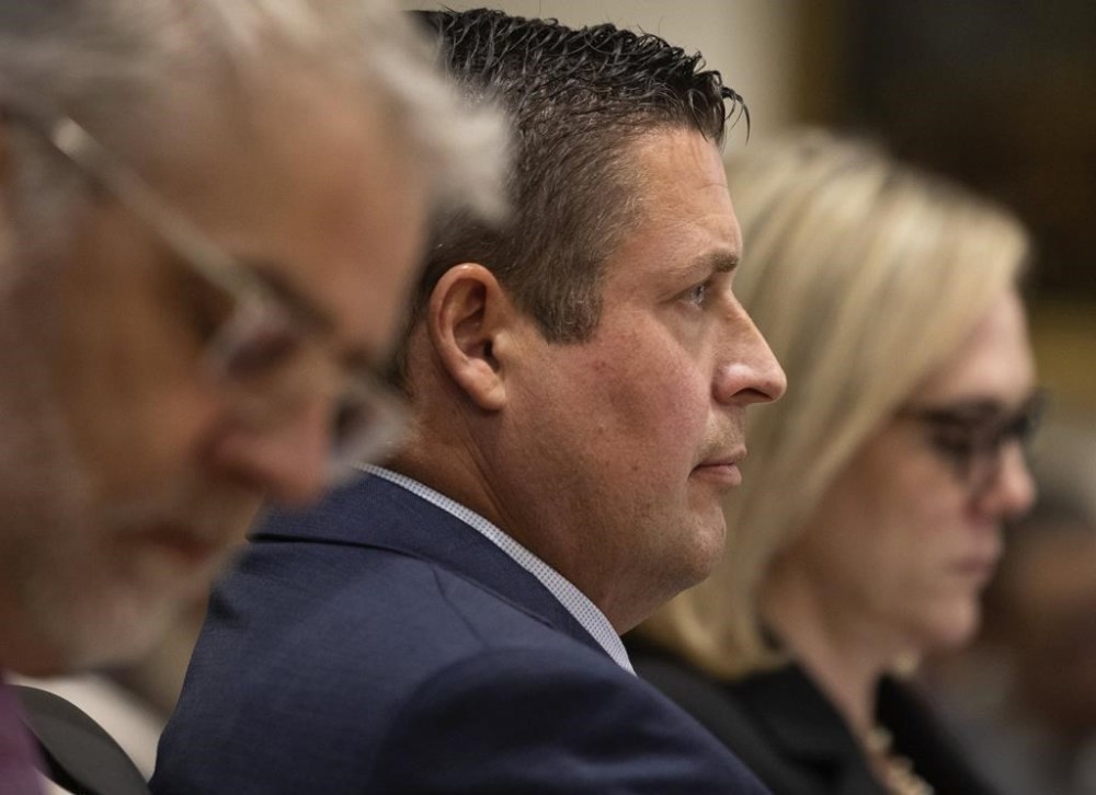 Auburn Police Officer Jeffrey Nelson, center, is flanked by two of his defense attorneys as Nelson's murder trial gets underway, Thursday, May 16, 2024 in Kent, Wash. On the left is Tim Leary, to the right is Emma Scanlan. Nelson is charged with murder in the death of a 26-year-old man outside a convenience store. (Ken Lambert